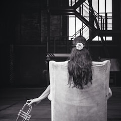 woman sitting on chair holding trumpet