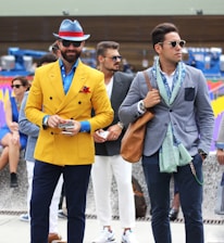 two man wearing yellow and grey suit jacket standing close together