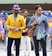 two man wearing yellow and grey suit jacket standing close together