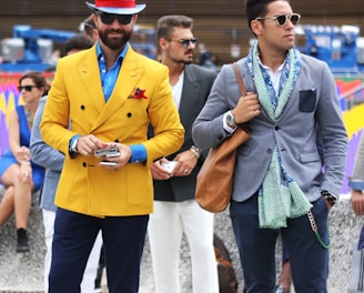 two man wearing yellow and grey suit jacket standing close together