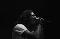 A black and white portrait of a singer lost in the emotion of a live performance.