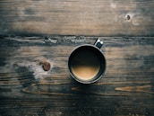 gray cup with brown liquid inside on top of table