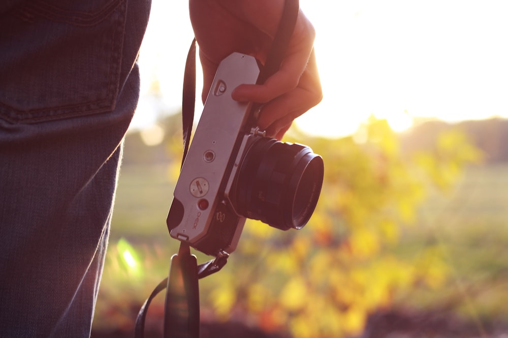 person holding bridge camera during daytime