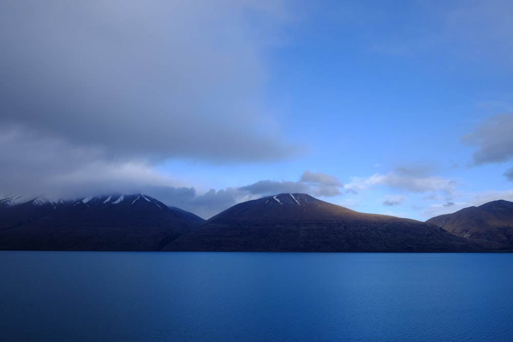 body of water in front of mountains