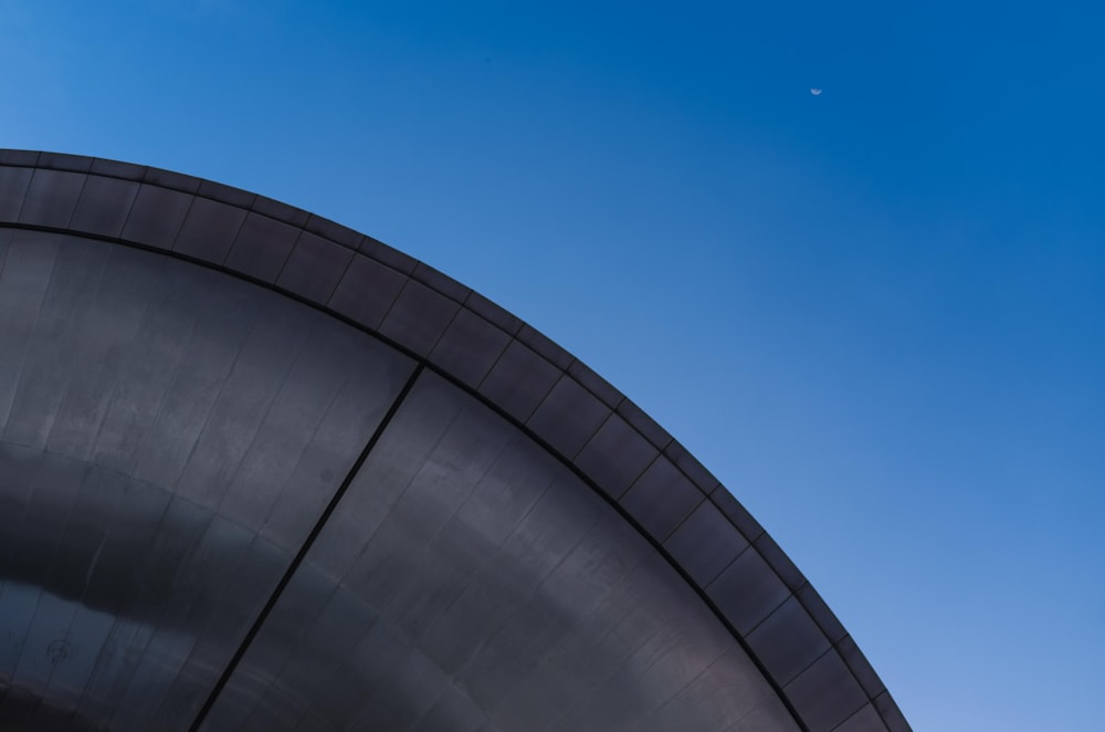 a plane flying in the sky over a building