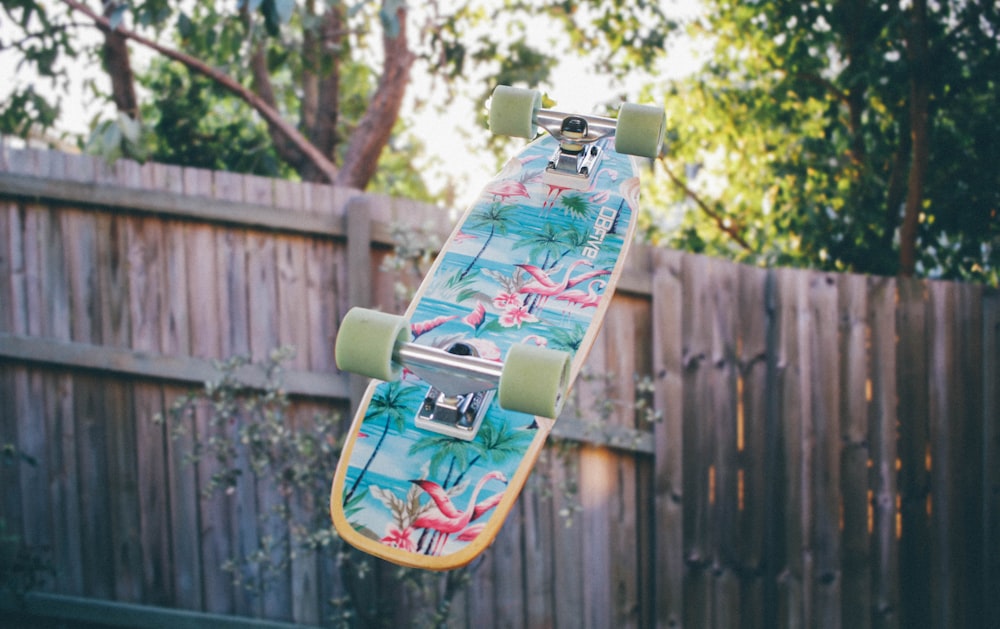 skateboard flipped near wooden fence
