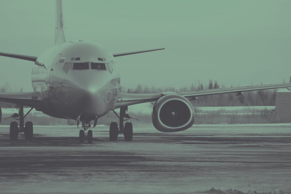Foto en escala de grises de un avión comercial en la pista