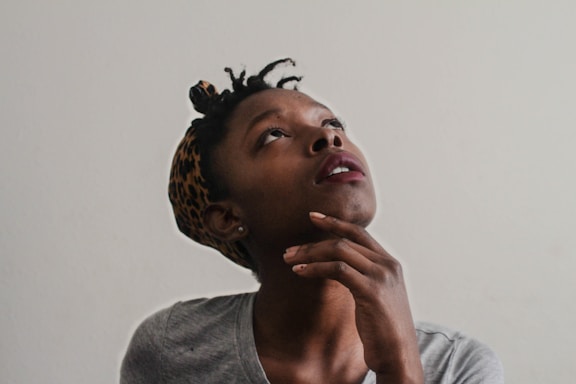 woman in gray top looking up with a questioning look