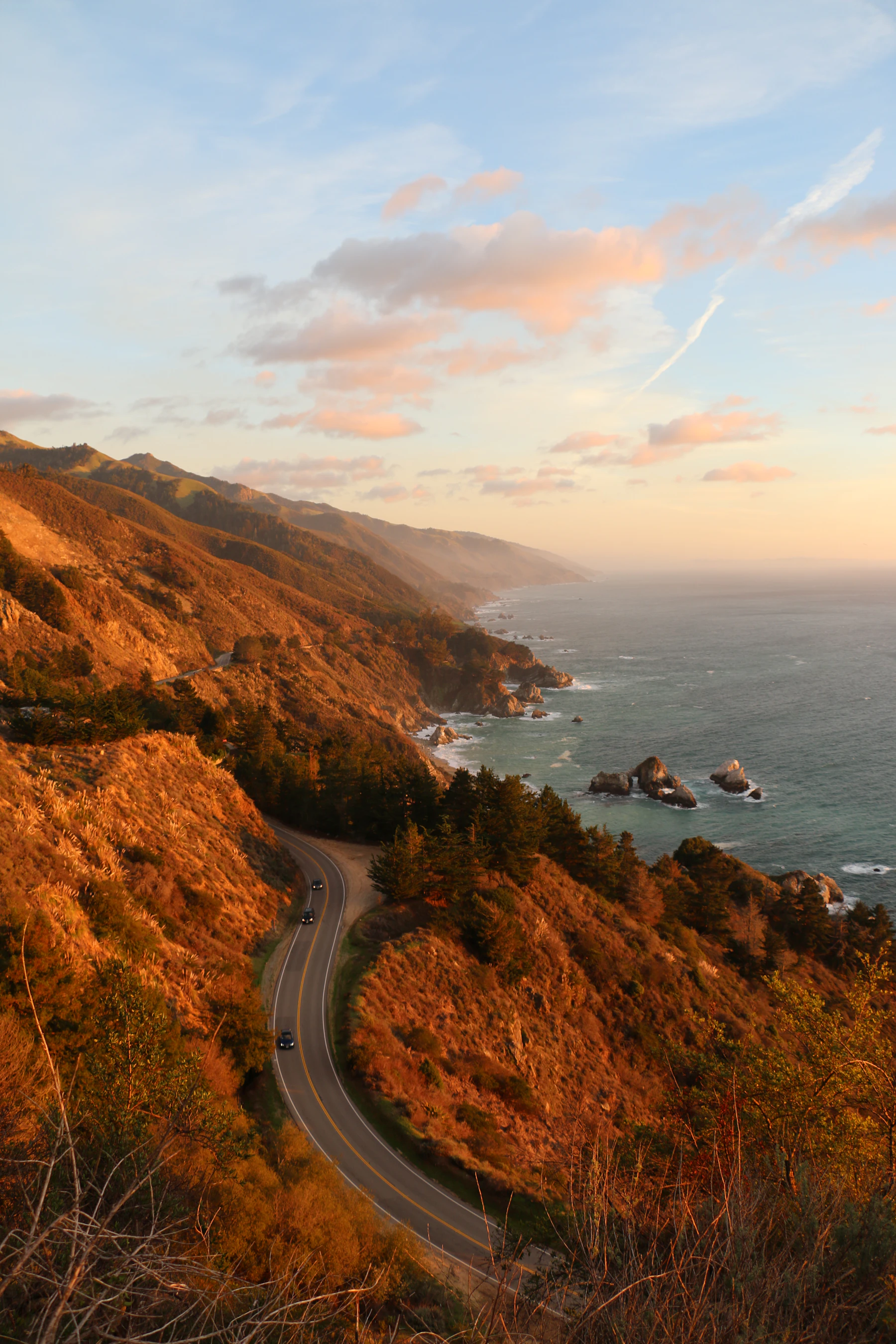 Highway 1 winding through Big Sur hills at golden hour