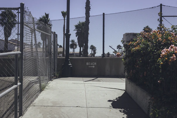 Beachfront pathway leading to a secure, gated community entrance.