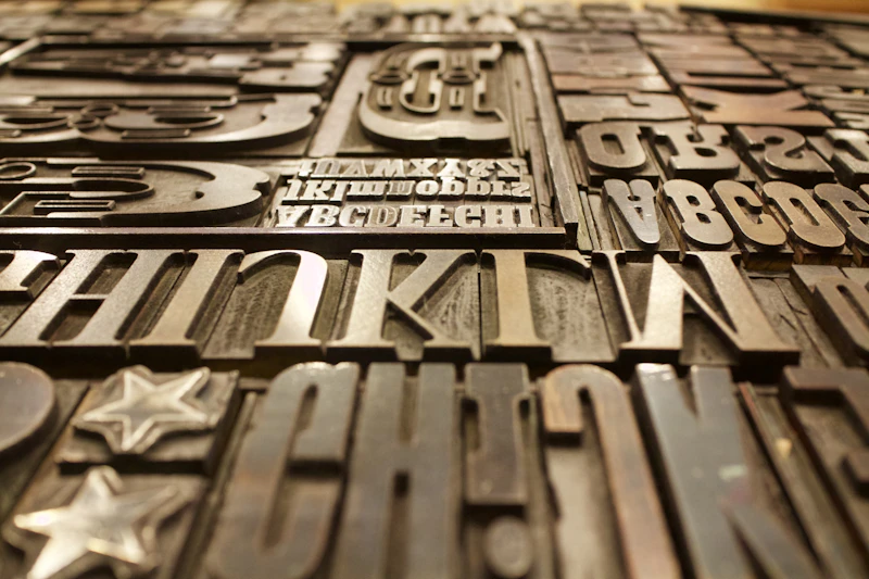 Logo Construction  -  close-up of vintage letterpress type characters, warm-toned printing blocks