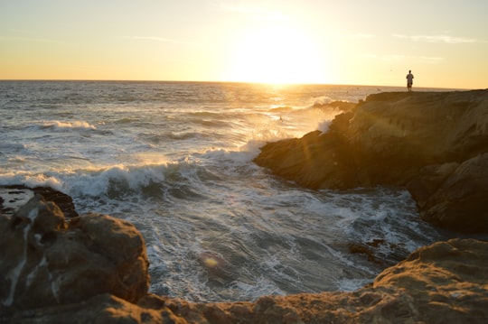 person on rock formation during sunset in Leo Carrillo State Beach United States