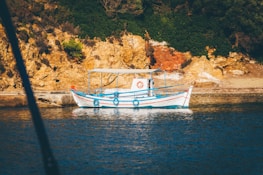 Aquamavi's service boat navigating calm blue waters near rocky shores.