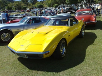 A vibrant photo of a classic car gleaming under the sun at a bustling car show.