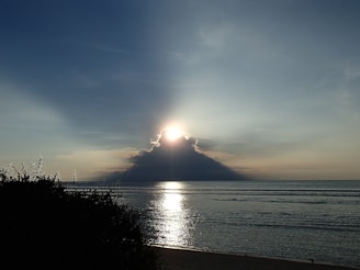 A soft-focus image of a sunrise over a calm sea symbolizing new beginnings.