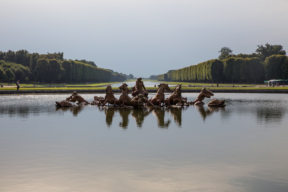 statue of horses on body of water at daytime