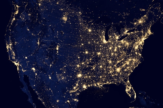 A detailed nighttime satellite view of global energy infrastructure hubs connected by subtle glowing lines.
