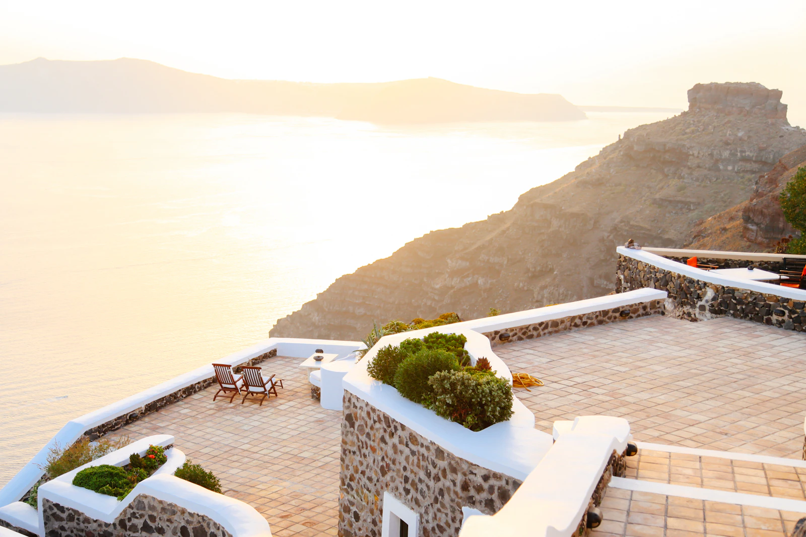 Aerial view of a Santorini clifftop terrace above the caldera and the Aegean Sea