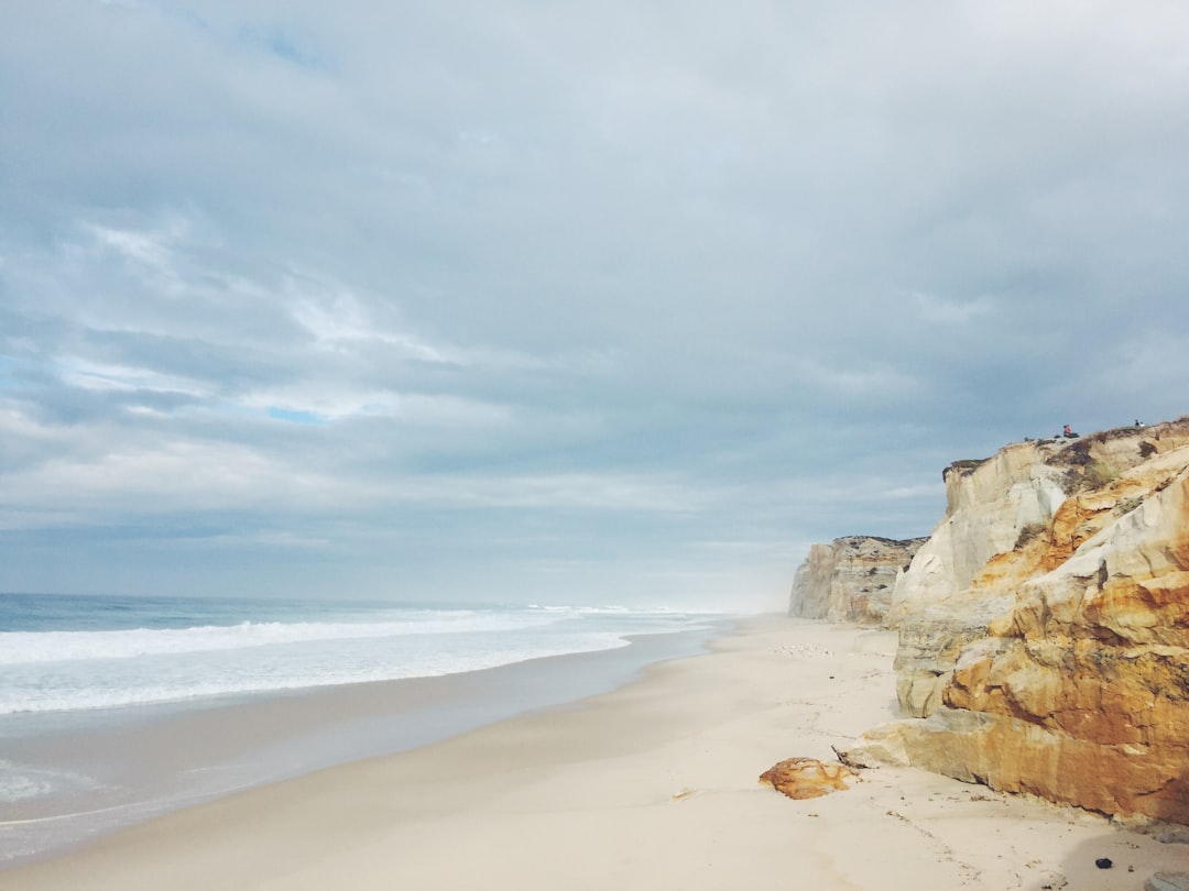 brown cliff beside ocean