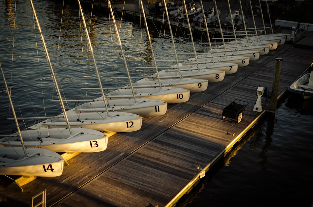 high-angle view of lined white boats on wooden bridge over body of water