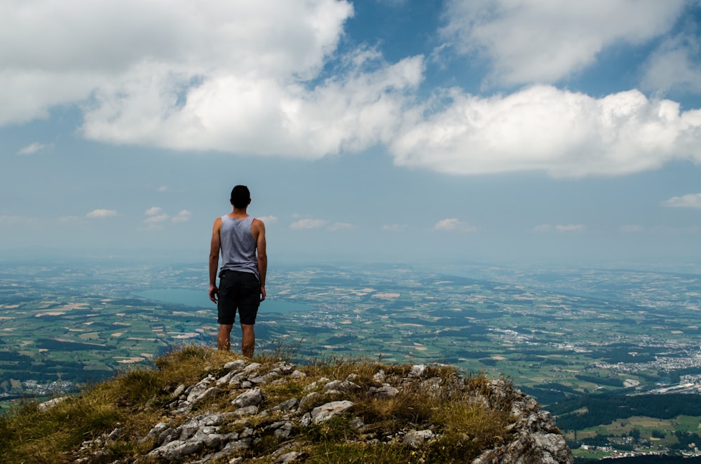 man standing at peak of mountain