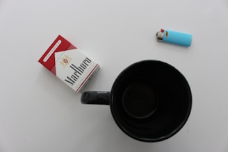 A clean, minimalist beige-toned photo showcasing a variety of lighters and rolling papers neatly arranged on a wooden surface.
