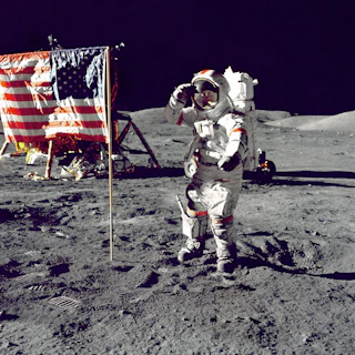 astronaut standing on moon beside U.S.A. flag