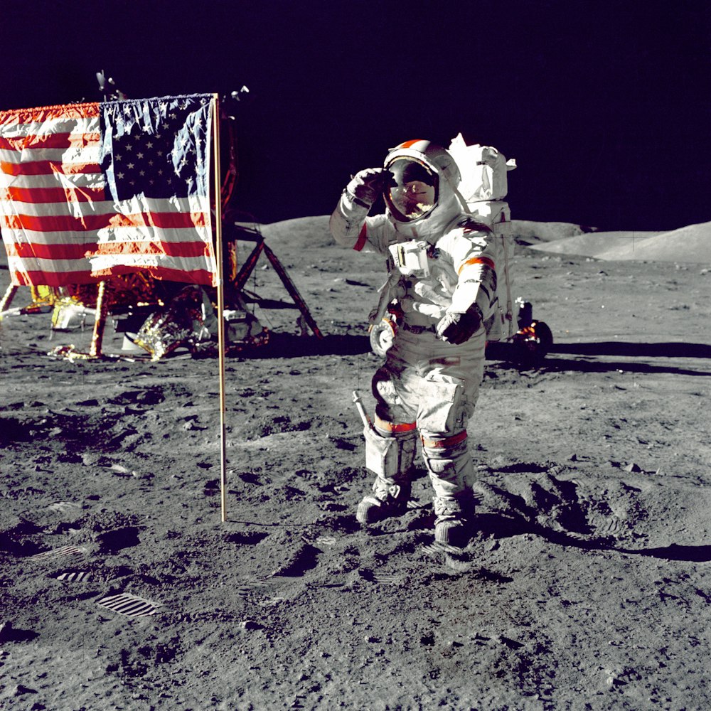 미국 국기 옆에 달에 서 있는 우주 비행사
