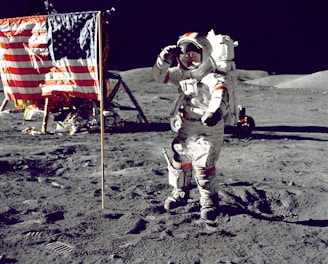 astronaut standing on moon beside U.S.A. flag