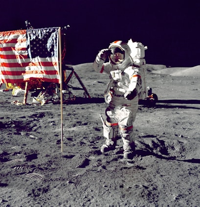 astronaut standing on moon beside U.S.A. flag