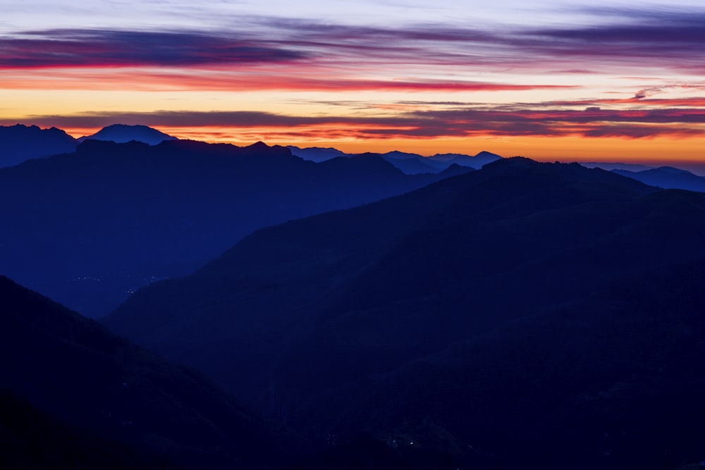 mountain ranges under orange sky during sunset