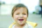 Smiling toddler playing outdoors on a sunny day, radiating health and happiness.