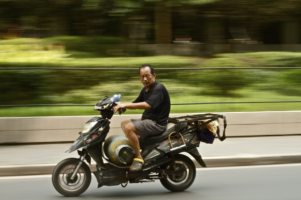 Photo d’un homme portant une chemise noire conduisant une moto