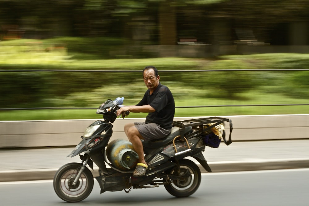 photo of man wearing black shirt riding motorcycle