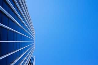 low-angle photography of curtain glass building under blue sky