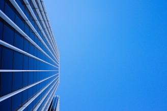 low-angle photography of curtain glass building under blue sky