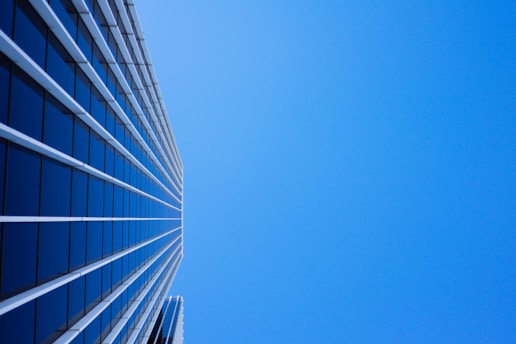 low-angle photography of curtain glass building under blue sky