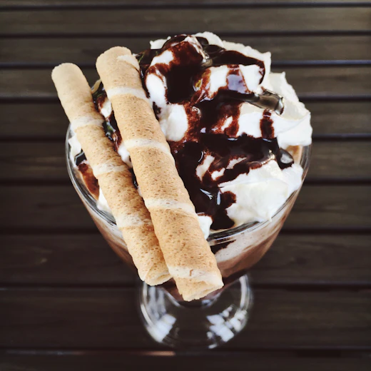 Chocolate sundae topped with whipped cream and sauce