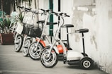 Row of different aged care scooters lined up in a clean workshop.