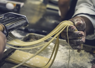 person sheeting dough