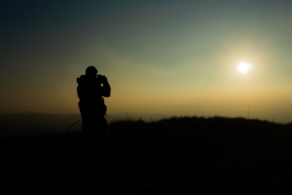 Silueta de hombre tomando fotografía durante la hora dorada