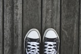 A pair of stylish canvas sneakers on a wooden surface.