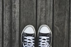 A pair of trendy sneakers on a wooden surface.
