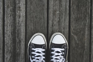 A pair of trendy sneakers placed on a wooden surface.