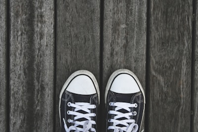 A pair of stylish low-top sneakers on a wooden surface.