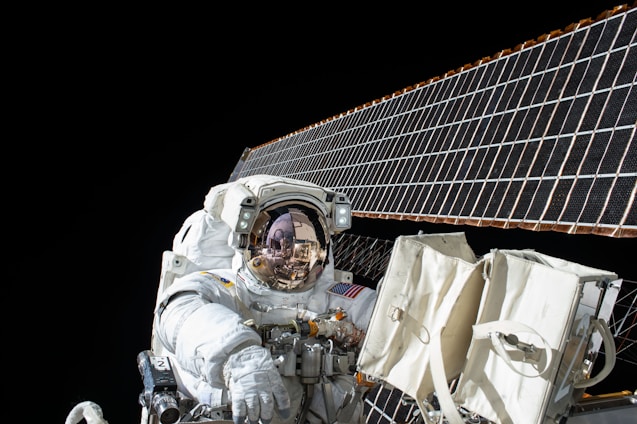 photography of Astronaut beside solar panel