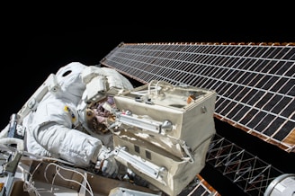 closeup photo of astronaut repairing satellite