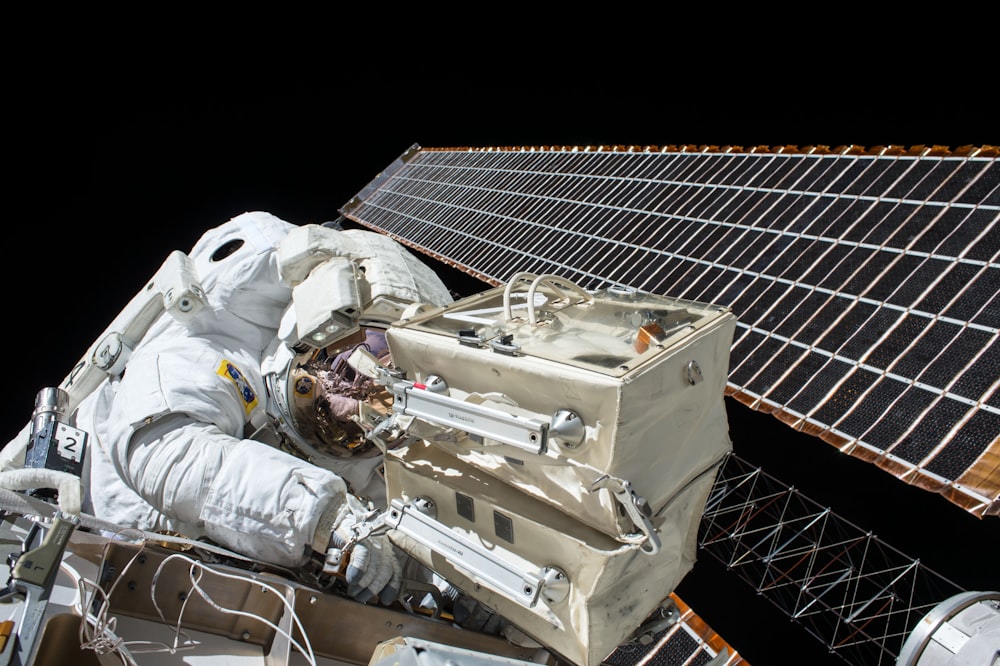 closeup photo of astronaut repairing satellite