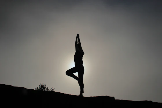 A standing balance held in silhouette at sunset
