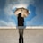 person standing on gray surface while holding umbrella